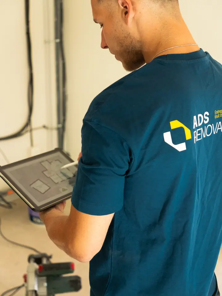 Diego, gérant d'ADS Rénovation, sur un chantier avec les plans