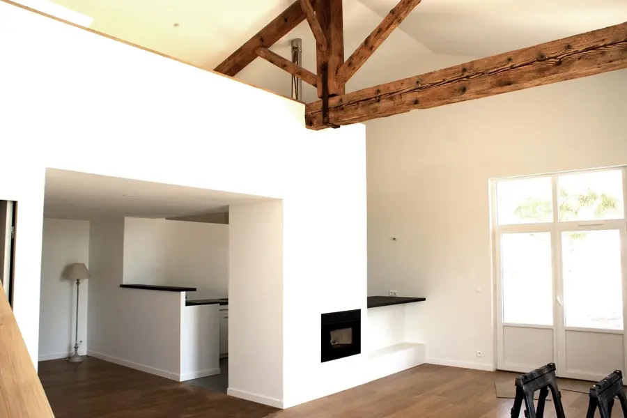 Volume réhabilité à Valbonne, charpente apparente et cheminée maçonnée